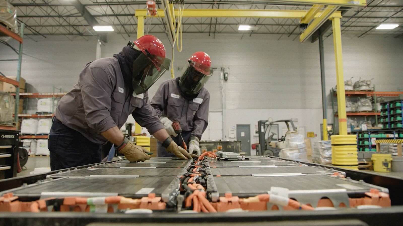 Technicians in protective gear inspecting an EV battery pack on the production line at Cirba Solutions