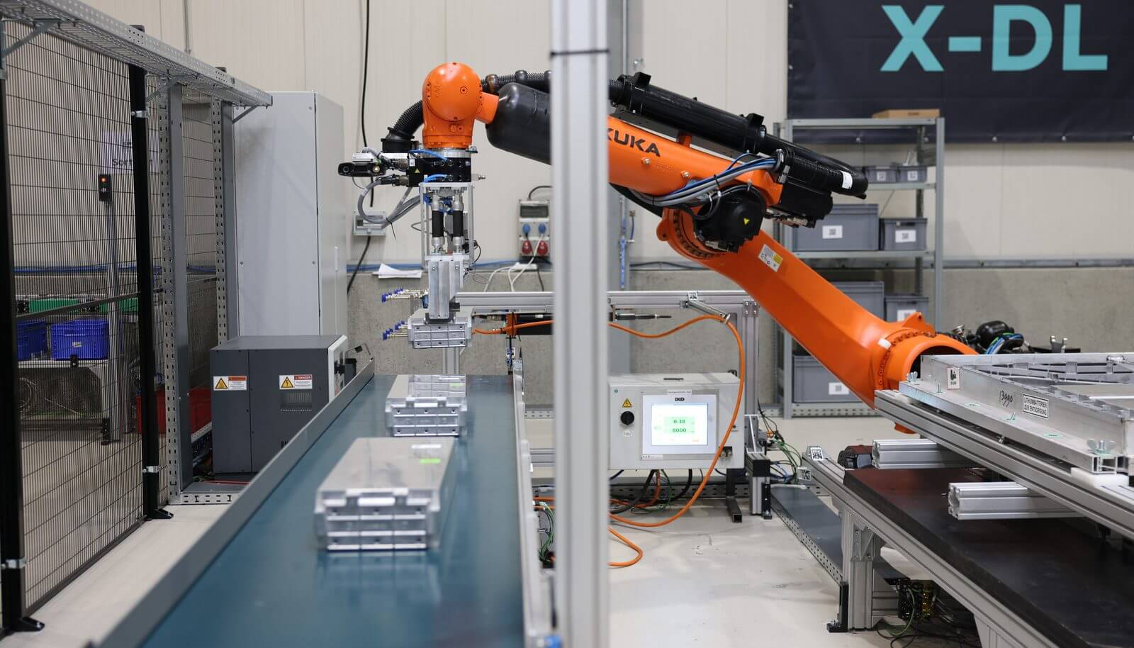 R3 Robotics robotic arm handling battery packs on a conveyor line